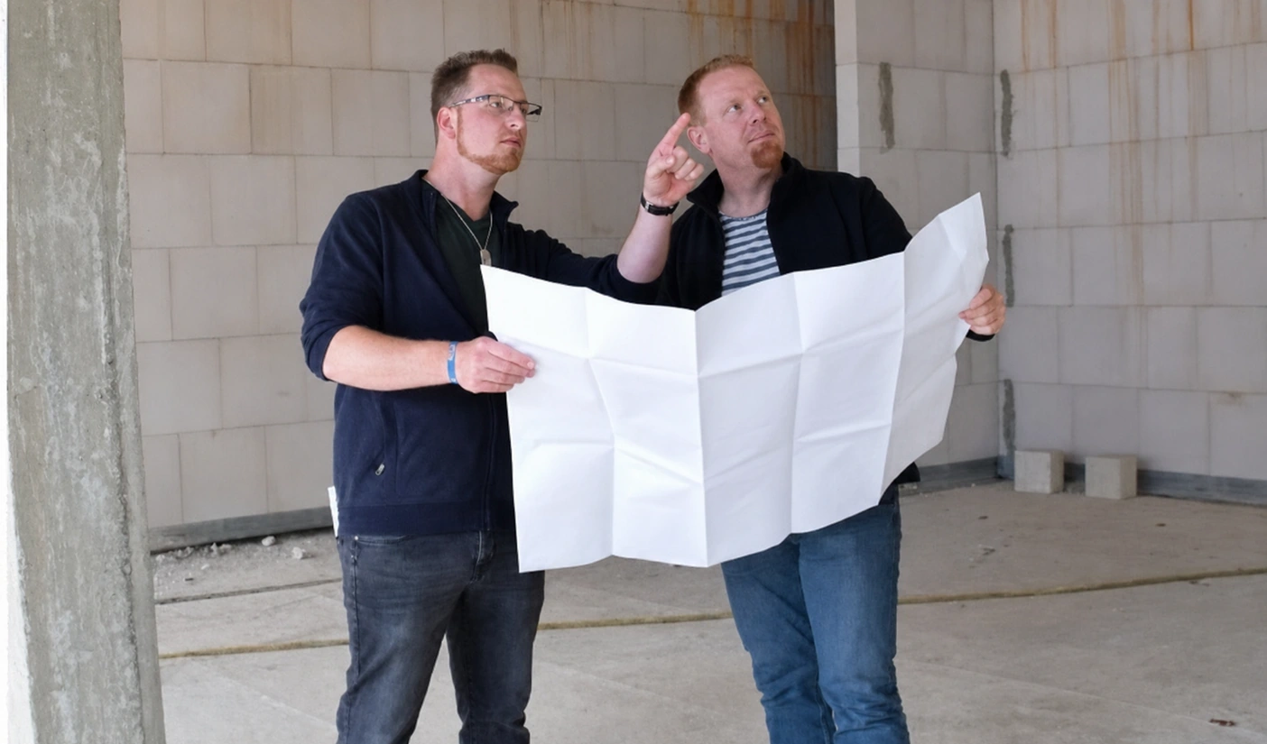 Kollegen des Ingenieurbüros PHHT prüfen einen Plan auf der Baustelle