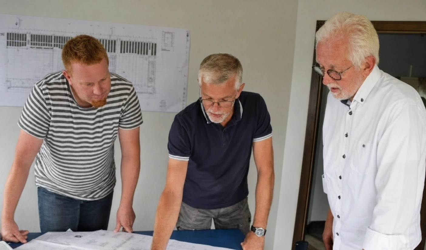 Kollegen des Ingenieurbüros PHHT besprechen Pläne im Büro